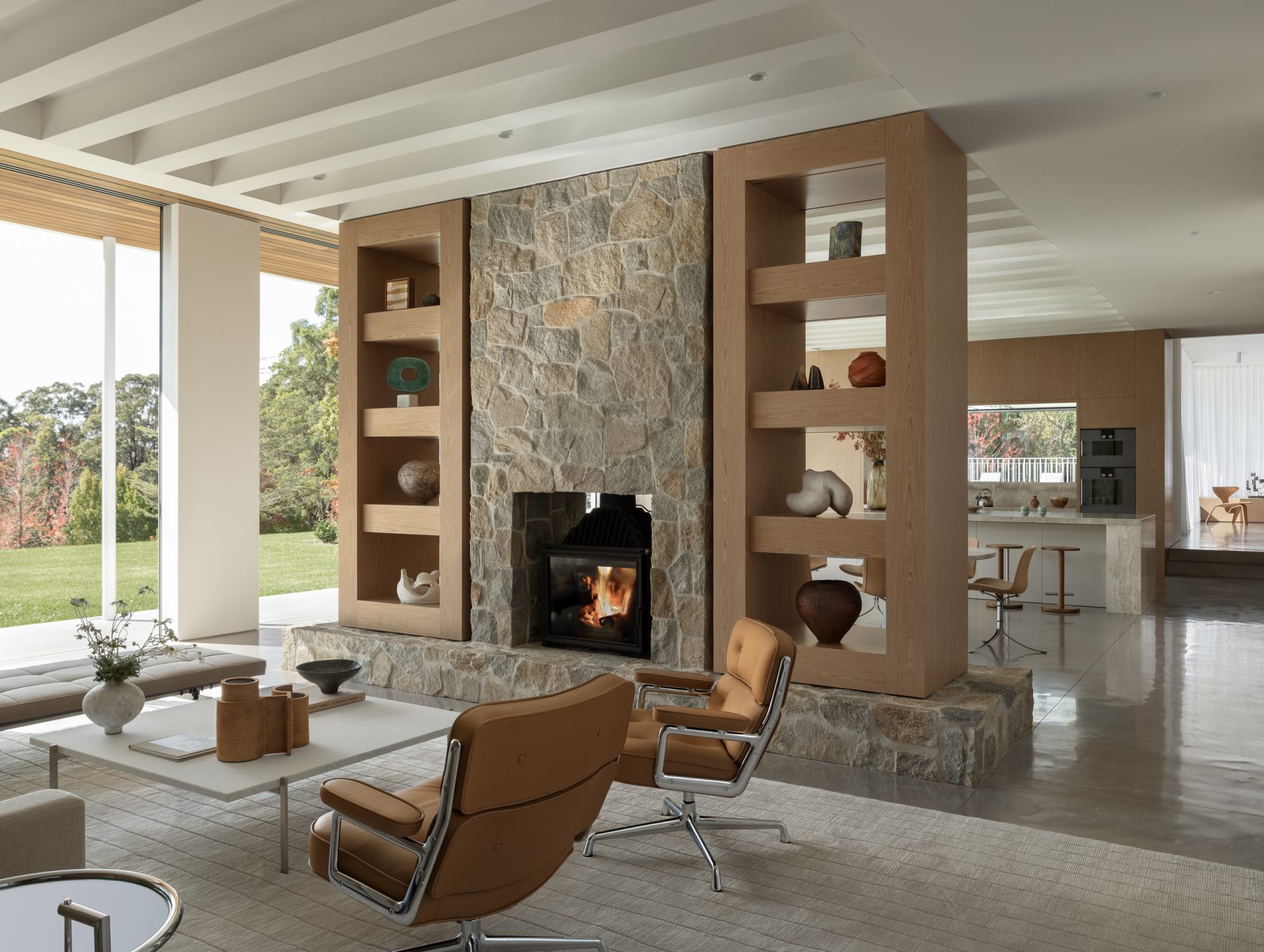 Living room with stone fireplace and timber joinery at Melody House
